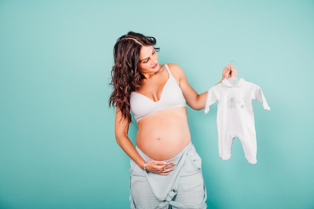 Mãe grávida prepara a roupa para o bebê | Foto Premium